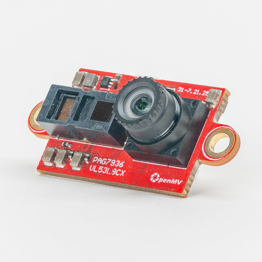 A small electronic camera module with a red printed circuit board, a black lens, and gold-tone metal mounting rings, photographed on a clean white background.