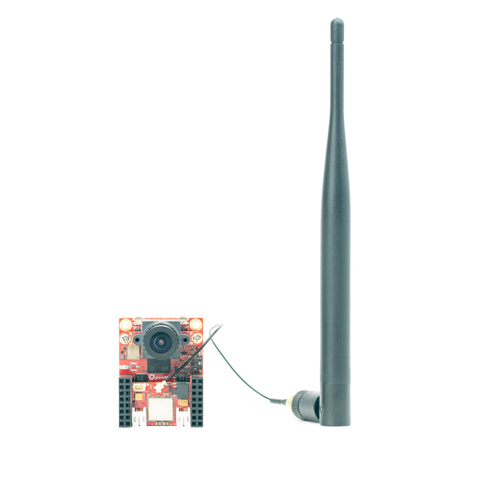 A small electronic camera module with a tall dark gray antenna attached by a thin wire, shown on a plain white background.