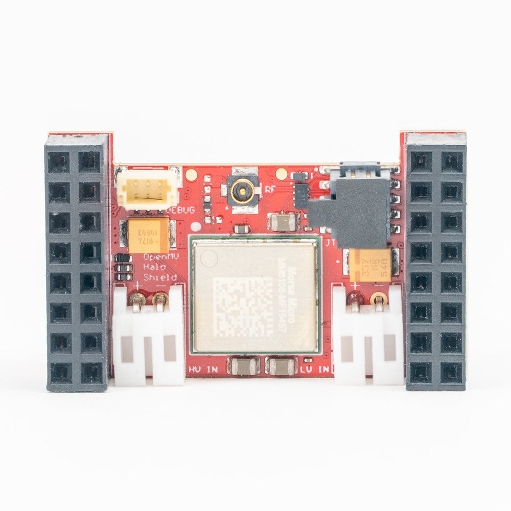 A red electronic circuit board module with various electronic components, connectors, and a central square sensor, photographed on a clean white background.