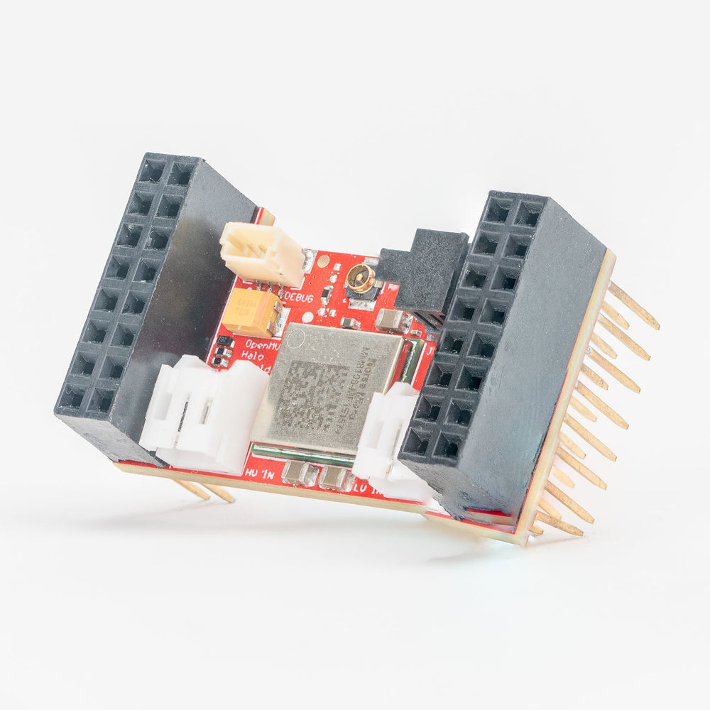 A small electronic circuit board module with a red PCB, black terminal blocks, a central gray chip, and several gold pins, photographed on a clean white background.