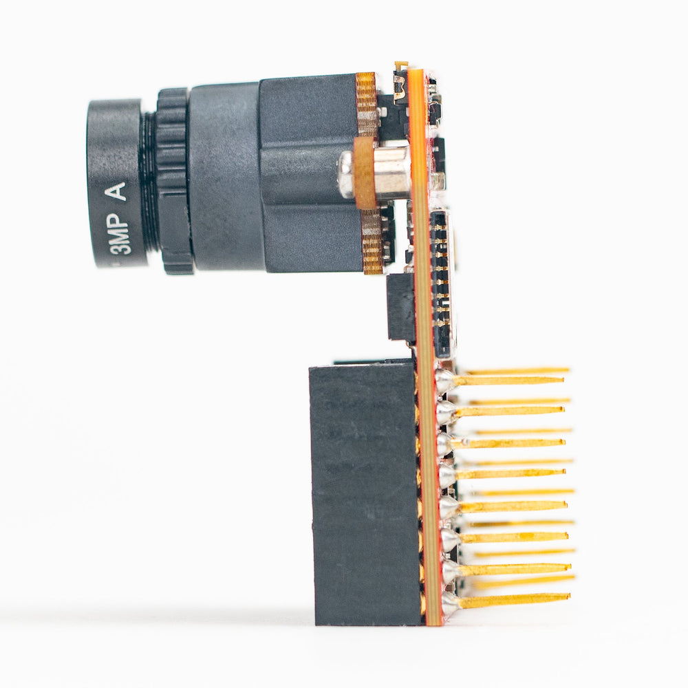 A compact electronic module with a black cylindrical lens-like component, gold circuitry, and a black rectangular base with multiple gold pins, photographed on a clean white background.